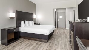 A modern hotel room with a large bed, bedside tables, a dresser, and a mirror. - Best Western Texas City I-45 (Texas City)