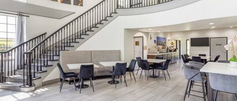Amplio espacio interior con escalera, asientos y una zona de cocina.