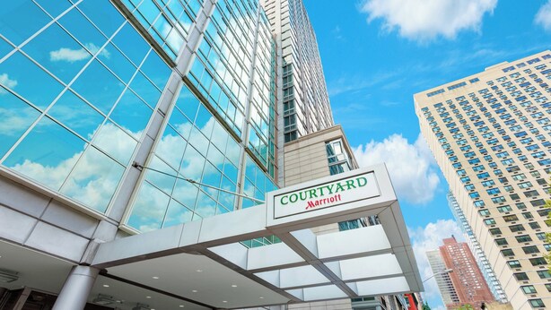 Un edificio moderno con fachada de vidrio y un letrero que dice "Courtyard Marriott".