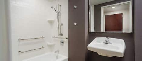Un baño con una bañera blanca, un lavamanos y una ducha con puerta de cristal.