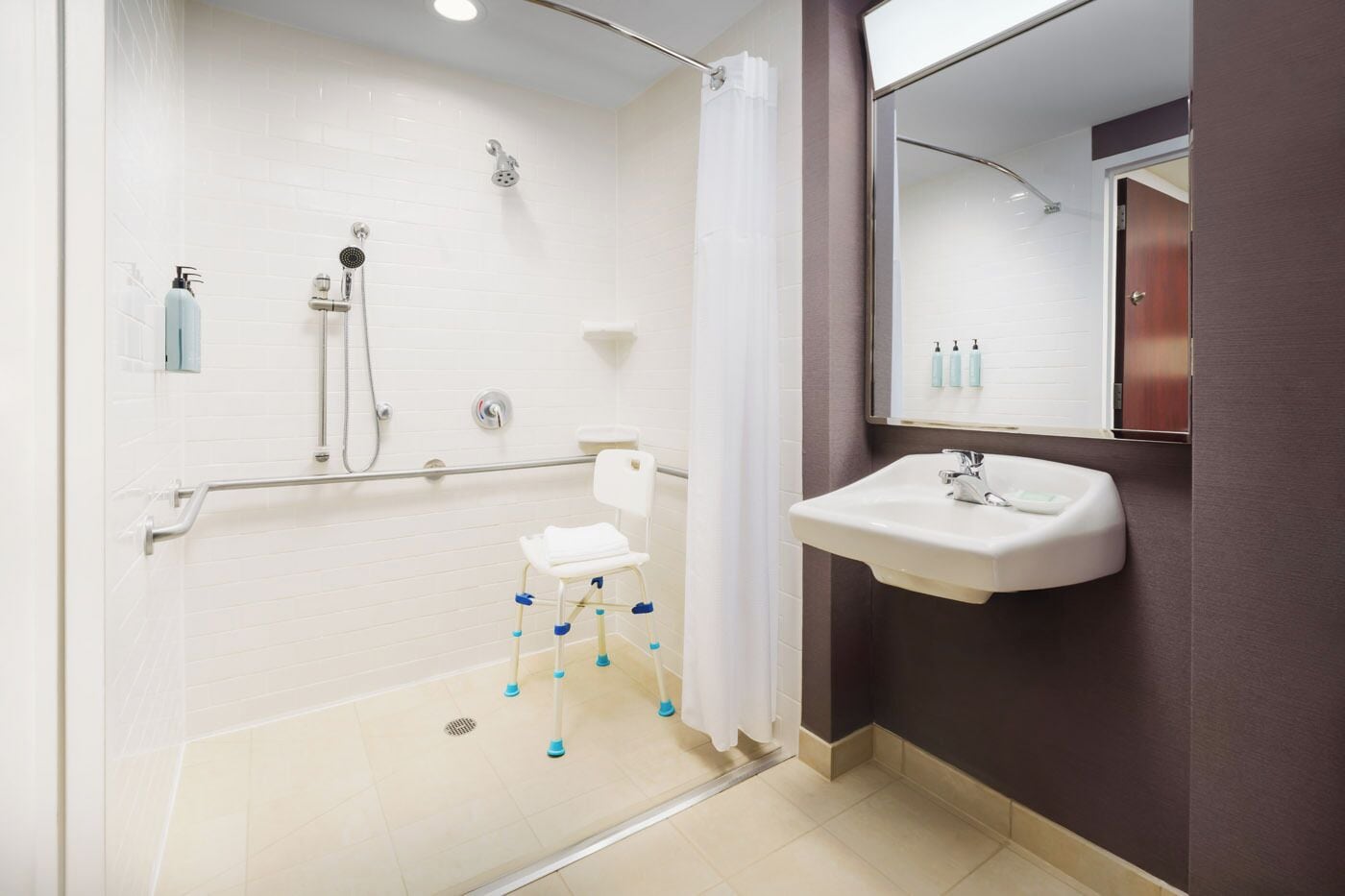 Ein Badezimmer mit Dusche, Toilette, Waschbecken und Spiegel.