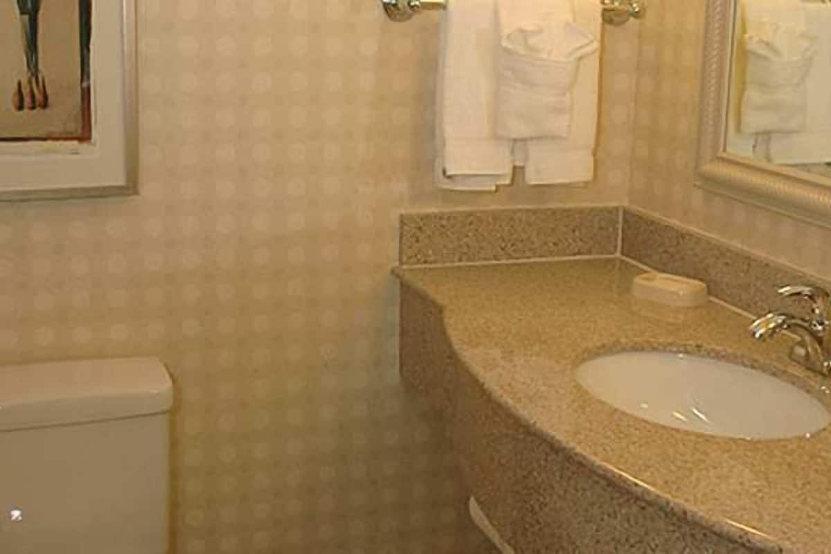 Une salle de bain équipée de toilettes, d’un lavabo et d’un porte-serviettes.