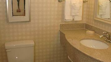 Un baño con inodoro, lavabo y perchero para toallas.
