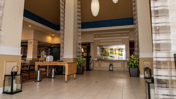 En rummelig lobby med reception, siddeområde og plantekasser.