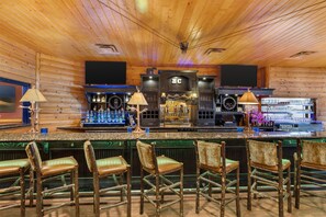 A bar with wooden walls and a wooden ceiling, featuring a bar counter with stools and a television screen above. - Hilton Garden Inn Missoula (Missoula)