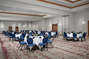 A large conference room with multiple round tables and blue chairs, equipped with white tablecloths and black centerpieces. - Hilton Garden Inn Missoula (Missoula)