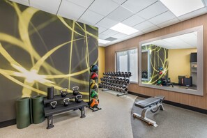 A gym with exercise equipment, a bench, and a mirror. - Hilton Garden Inn Missoula (Missoula)
