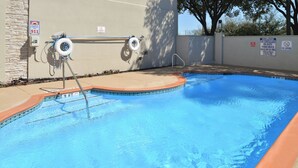 Ein Schwimmbecken mit einer Rettungswache, einem Notruf-Telefon 911 und Schildern, die das Tauchen verbieten.
