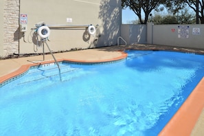 Une piscine équipée d’un poste de surveillance pour les sauveteurs, d’un téléphone pour appeler le 911 en cas d’urgence et de panneaux indiquant qu’il est interdit de plonger.