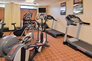 Un centre de remise en forme équipé de matériel de cardio, notamment des tapis de course, un vélo elliptique et un vélo d’appartement.