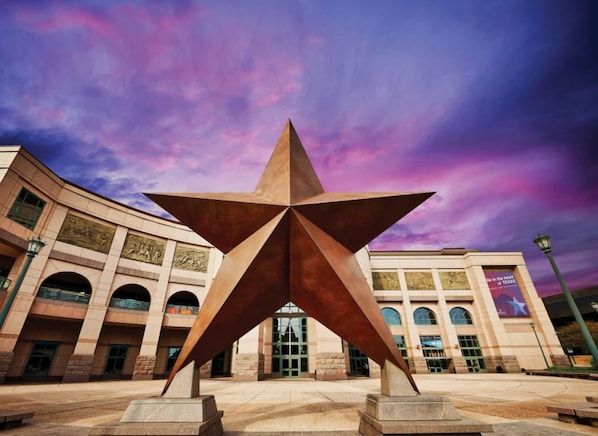 A star-shaped sculpture in front of a building with arched windows and a banner.