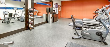 A gym with cardio machines, weight equipment, and a reception area.