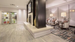 A hotel lobby with a reception desk, seating area, and a display of colorful vases. - Hampton Inn & Suites Denver-Downtown (Denver)