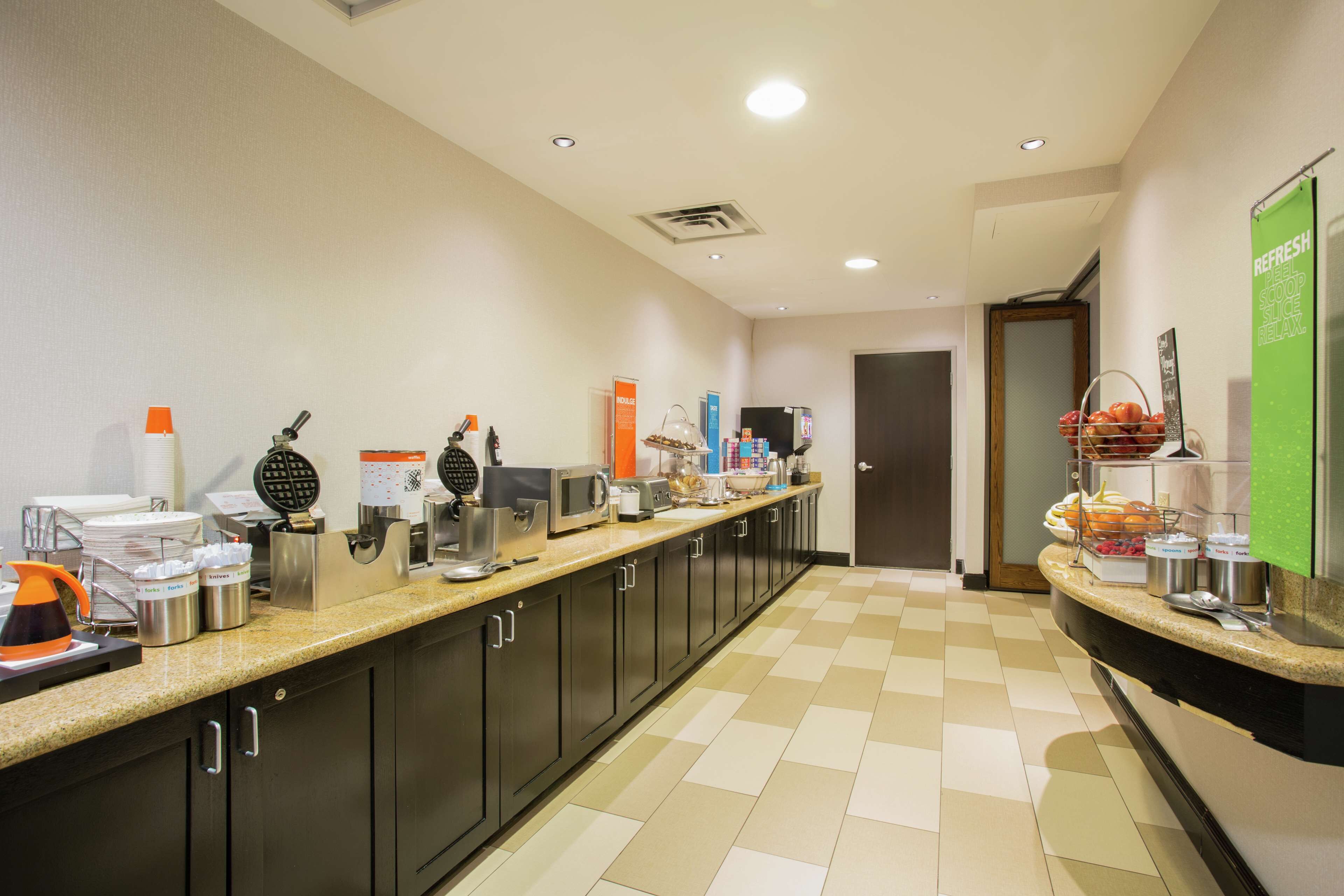 Eine Hotelküche mit einer langen Theke, ausgestattet mit verschiedenen Geräten und Lebensmitteln.