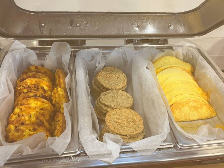 A buffet with three trays containing different food items.
