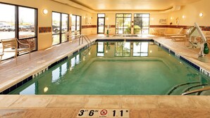 Une piscine intérieure à l’eau claire, avec des repères indiquant la profondeur et un panneau interdisant de plonger.