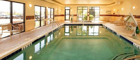 An indoor swimming pool with clear water, marked depth lines, and a no diving sign.