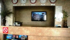 A lobby with clocks displaying times from Mumbai, London, New York, Beijing, and Paris.