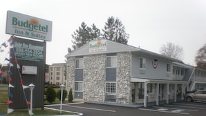 A building with a sign for Budgettel Inn & Suites, indicating it is under new management.