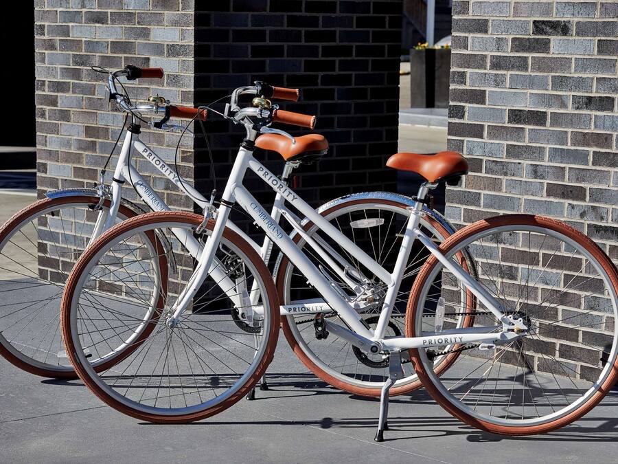 Bicicleta blanca amb selles de pell marró i rodes marrons, aparcada davant d'un mur de rajola.