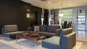 Un lobby moderno con sofás, una mesa de centro y una estantería.