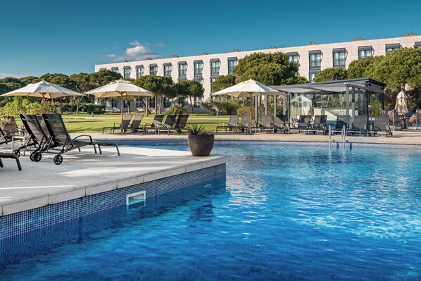 Una piscina al aire libre, sombrillas