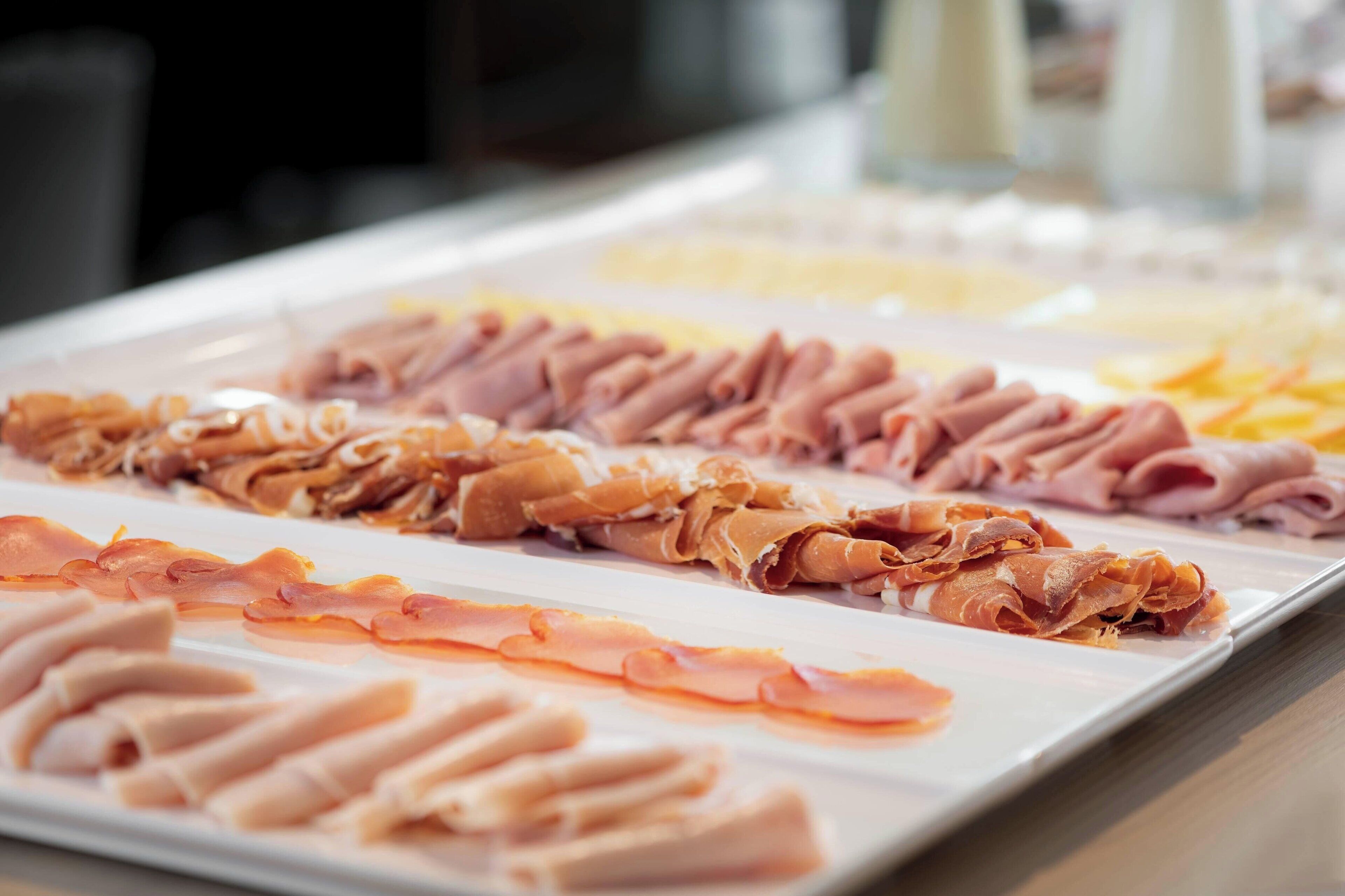 Un bufé con diversas carnes y quesos.