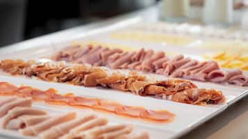 Un bufé con diversas carnes y quesos.