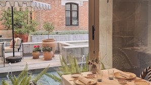 A dining area with a table set for two, a small fountain, and potted plants. - Hospes Palacio de los Patos, a Member of Design Hotels (Granada)