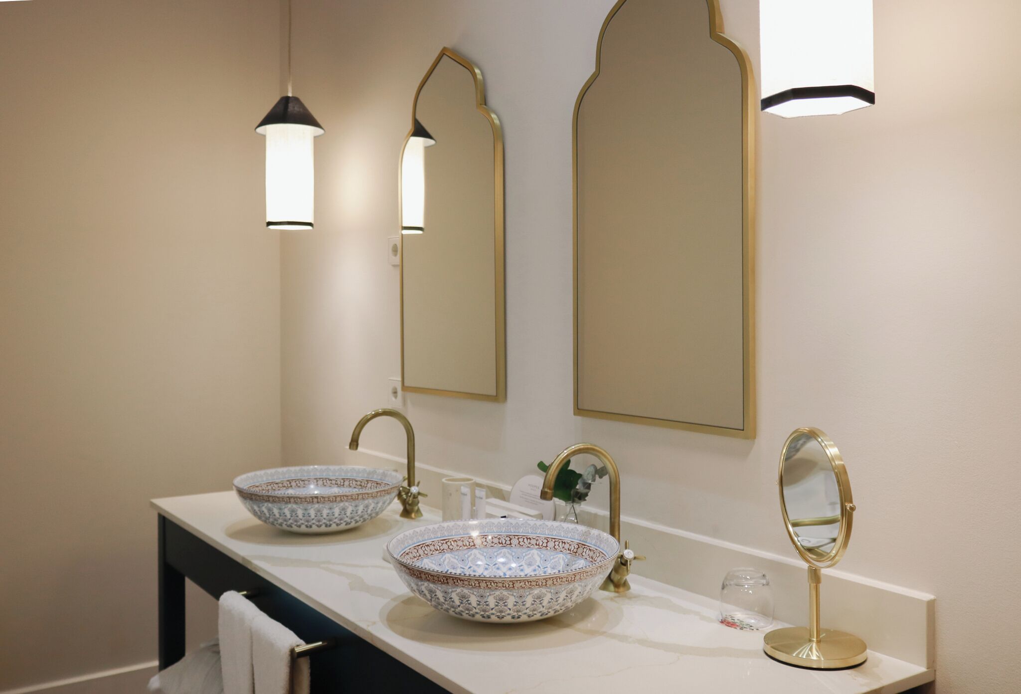 Un baño con dos lavamanos sobre encimera, un espejo e iluminación empotrada.
