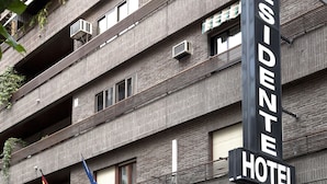 Un hôtel avec une enseigne indiquant « Hôtel Président » et plusieurs drapeaux.