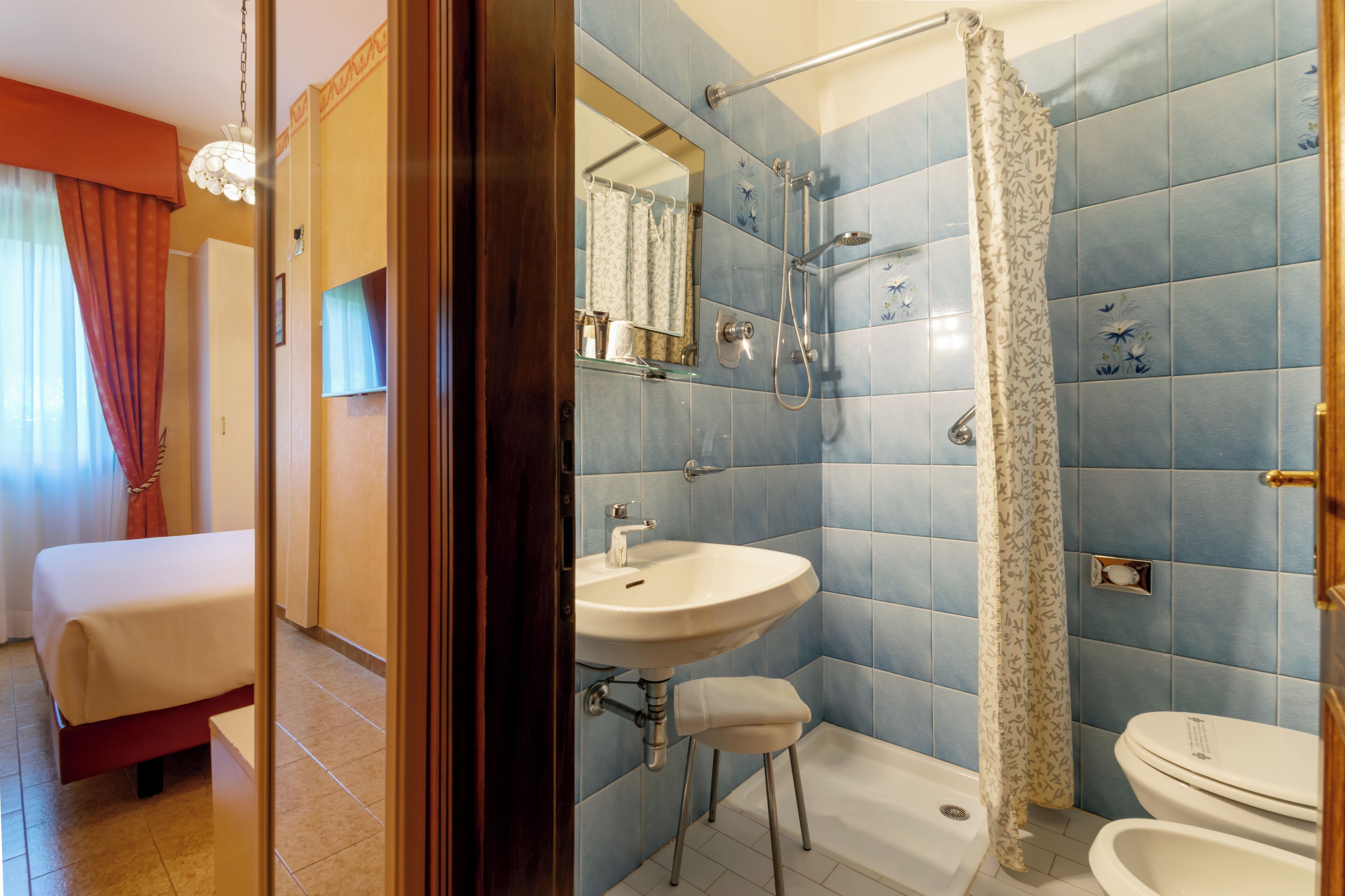Une salle de bain d’hôtel équipée d’une douche, d’un lavabo et de toilettes.