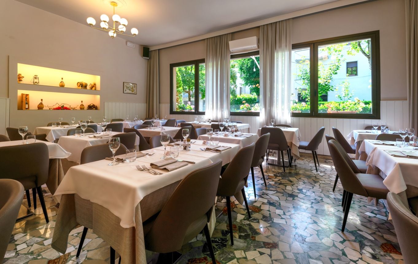 Ein Restaurant mit mehreren Tischen, Stühlen und einem Fliesenboden.