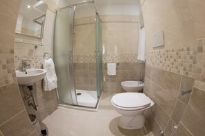 Driepersoonskamer | Badkamer | Een haardroger, een bidet, handdoeken