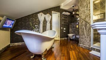A bathroom with a freestanding bathtub, a shower, and a toilet.