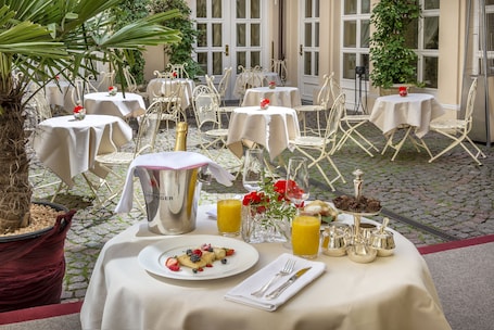 A breakfast setup with tables, chairs, and a variety of food and drink items.