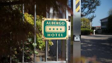 A sign for Albergo Hotel with a three-star rating.