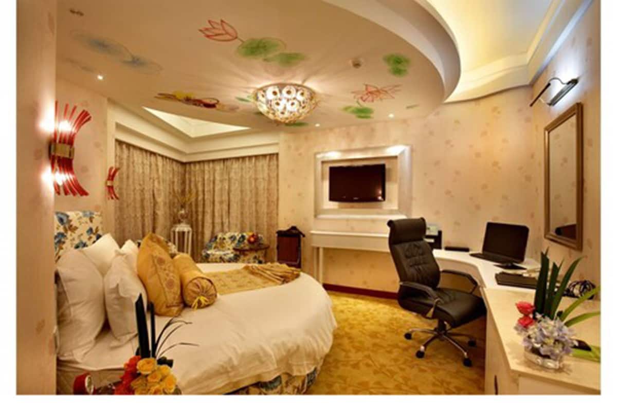 Een hotelkamer met een bed, bureau, stoel en een televisie.