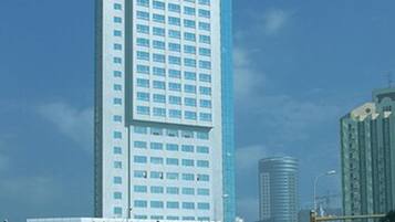 A tall, modern building with a prominent red logo at the top.