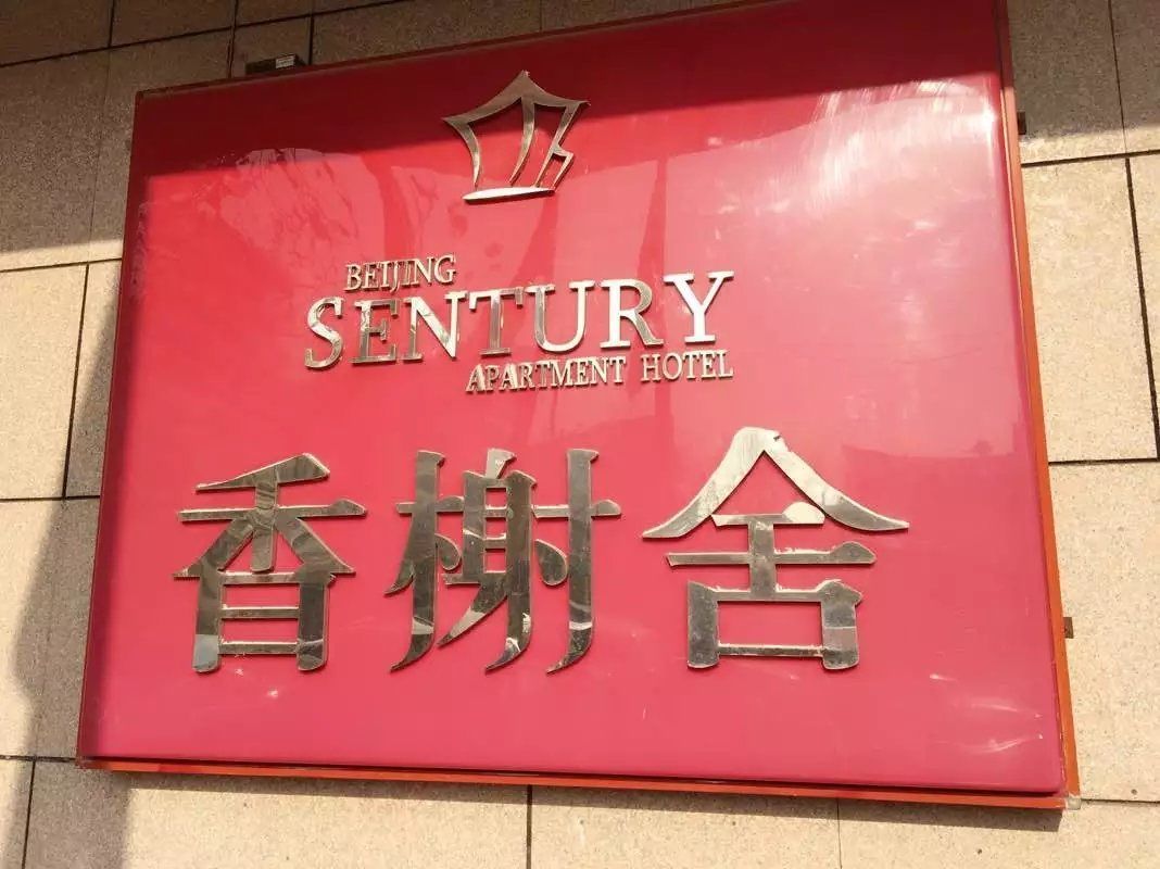 A sign for Beijing Sentury Apartment Hotel with a crown symbol above the name.