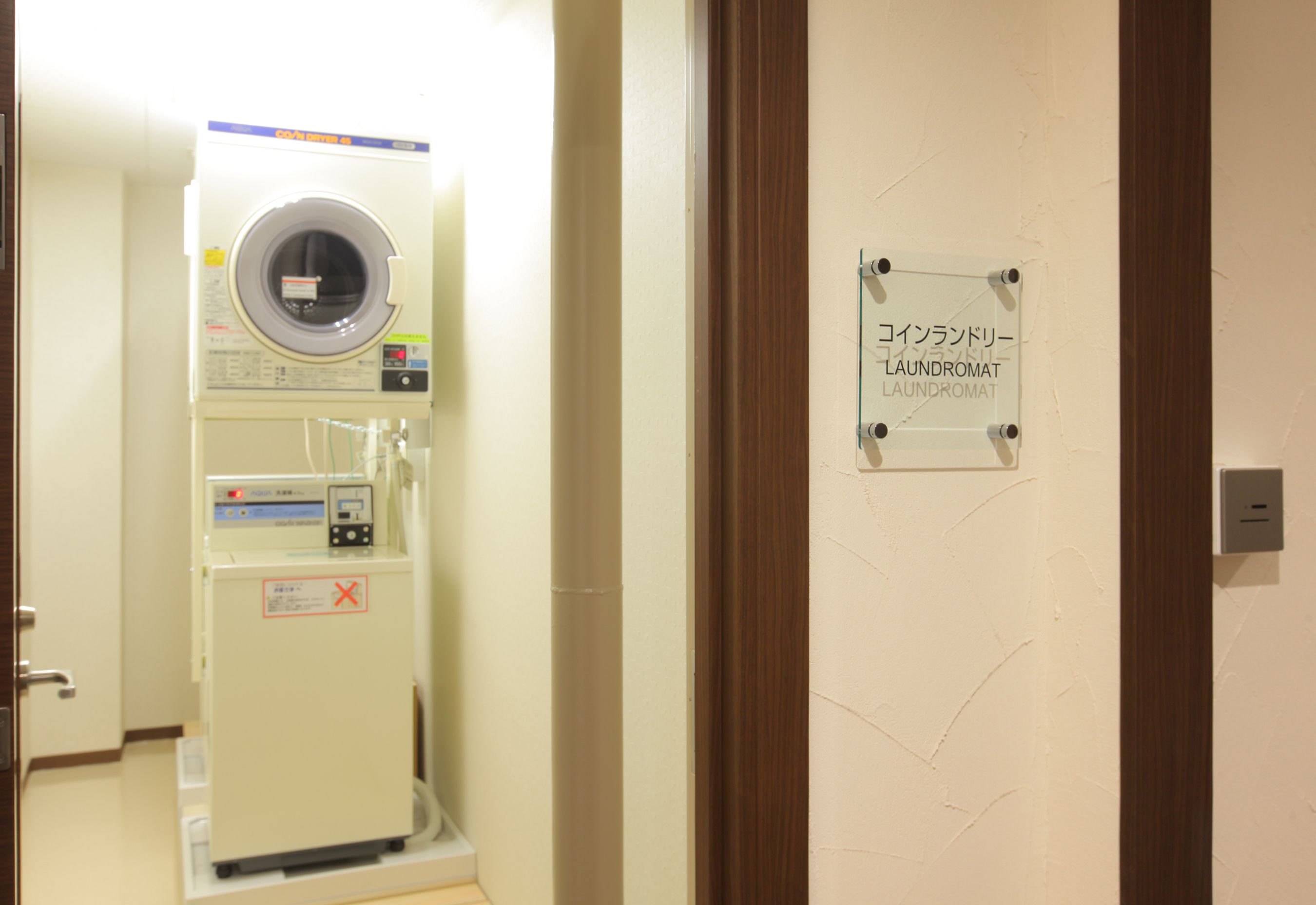 Una máquina de diagnóstico médico, una puerta con un cartel y un marco de madera.