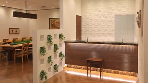 Un intérieur moderne avec un comptoir d’accueil en bois, un parquet à motifs en chevrons et un mur orné d’un motif géométrique.