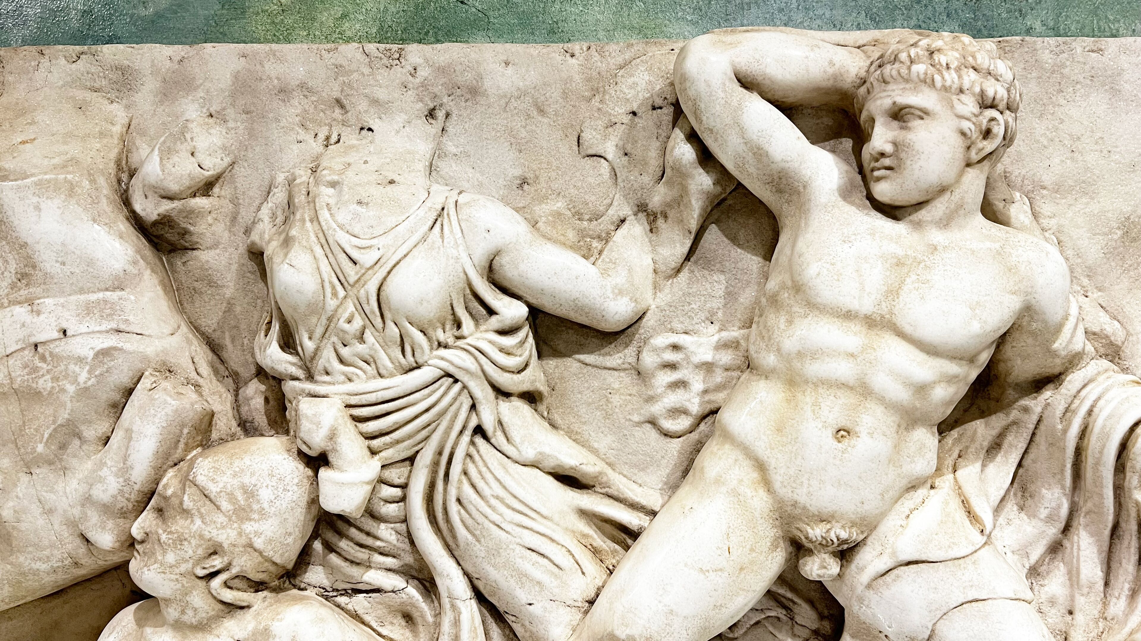 A marble relief sculpture with figures in dynamic poses, likely depicting a mythological or historical scene.