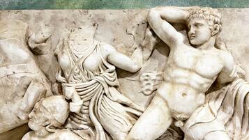 A marble relief sculpture with figures in dynamic poses, likely depicting a mythological or historical scene.
