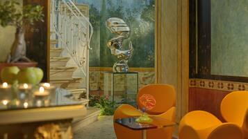 A room with a staircase, a sculpture, and orange chairs.