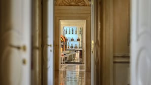 A hallway leading to a room with a glass display case containing bottles. - Byblos Art Hotel Villa Amista (San Pietro in Cariano)