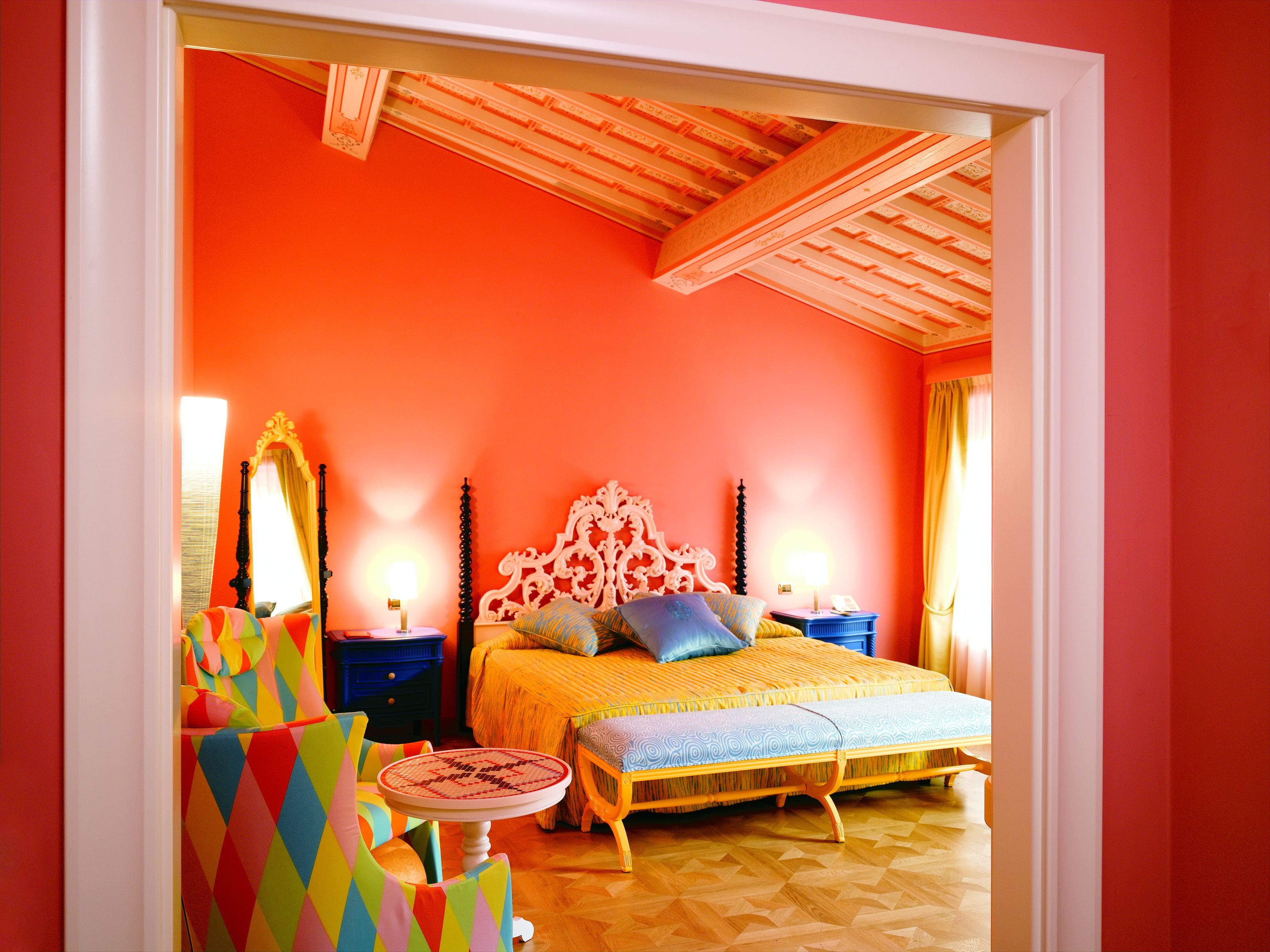 A bedroom with a bed, bedside tables, a chair, and a mirror.