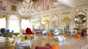 A spacious lobby with ornate chandeliers, colorful seating, and classical architecture. - Byblos Art Hotel Villa Amista (San Pietro in Cariano)