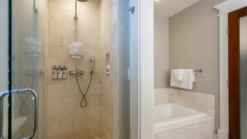 Une salle de bain moderne avec une douche à parois de verre, une baignoire sur pied et un porte-serviettes.