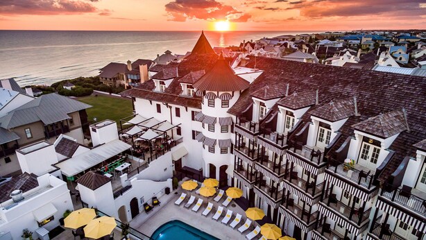 Ett semesterhotell med pool, solstolar och parasoller.